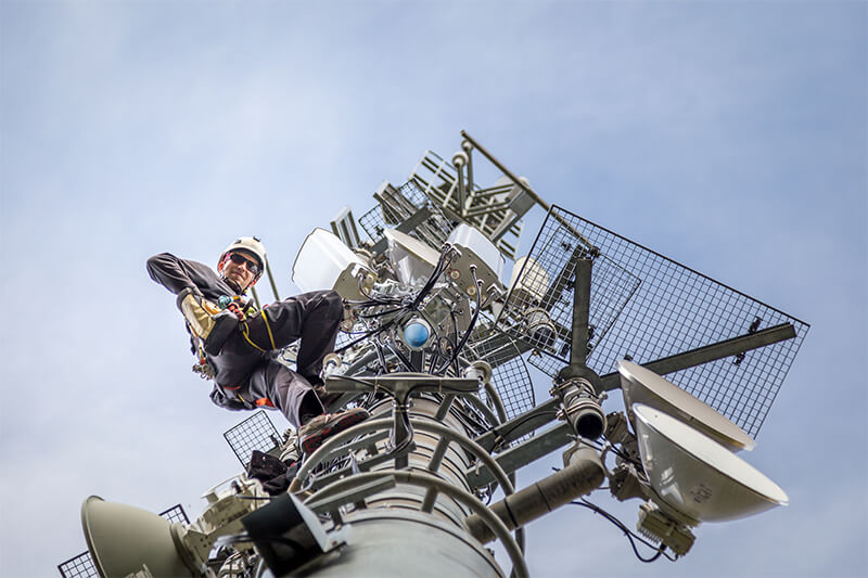 Man peers down from communications tower