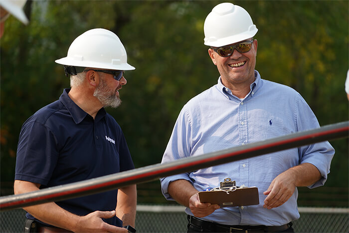 Two workers with hard hats discussing plans