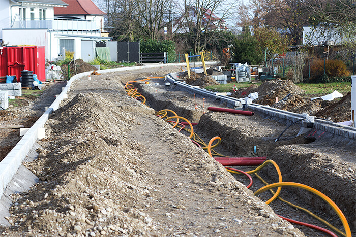 Laying a fiber optic cable for fast internet, Electricity and telephone cable along a new street. Cable Installation power lines at city street, industrial electricity and communication concept.