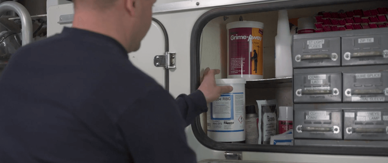 Ein Leitungsmonteur holt einen Reiniger für Gummierzeugnisse aus seinem Kranwagen