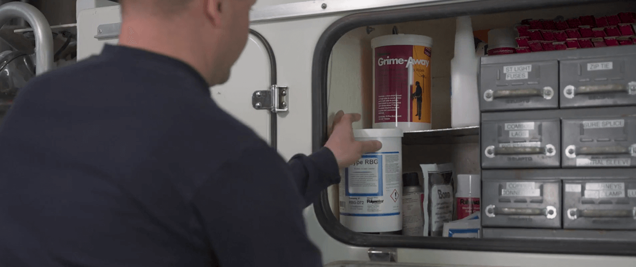 Un monteur de lignes sort le nettoyant pour produits en caoutchouc de son camion-nacelle.