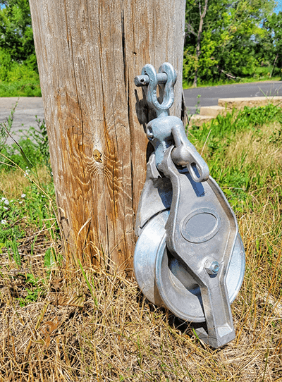 A stringing block leaning against a utility pole