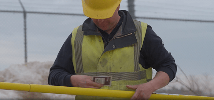 Ein Leitungsmonteur vor Ort holt ein Polywater Wischtuch für Betätigungsstangen hervor, während er seine Betätigungsstange hält
