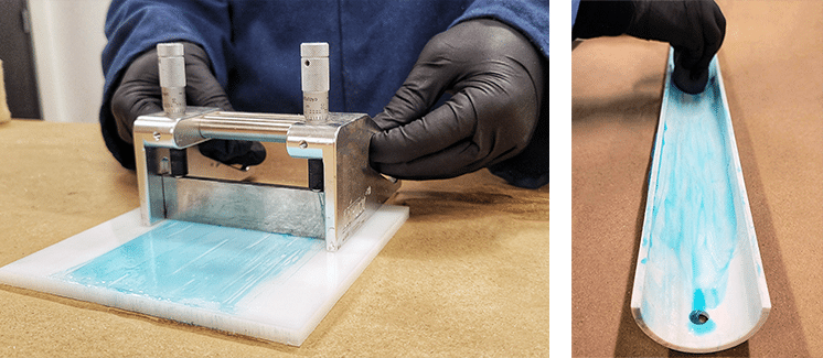 In the first image, two black-gloved hands spreads a thin film of blue lubricant on a white tile using a silver, flat, metal piece. In the second image, a black-gloved hand spreads blue lubricant on a white conduit.