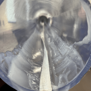 Image de l'intérieur d'un conduit dans lequel on a appliqué du lubrifiant. Le lubrifiant blanc s'accumule au fond du conduit.