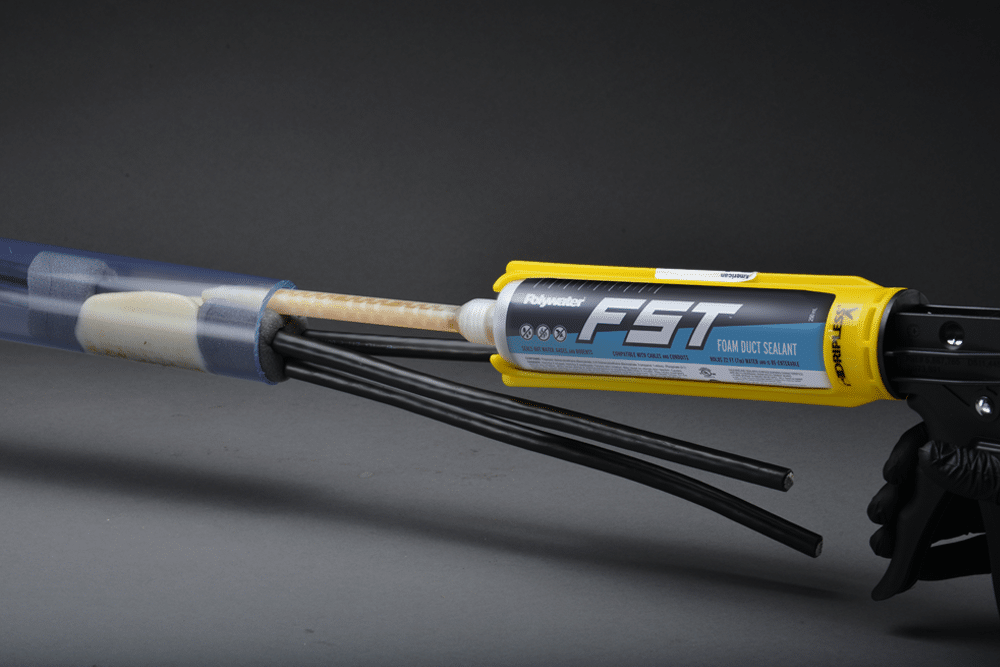 Polywater FST expanding foam sealant being squeezed into a clear conduit to seal it.